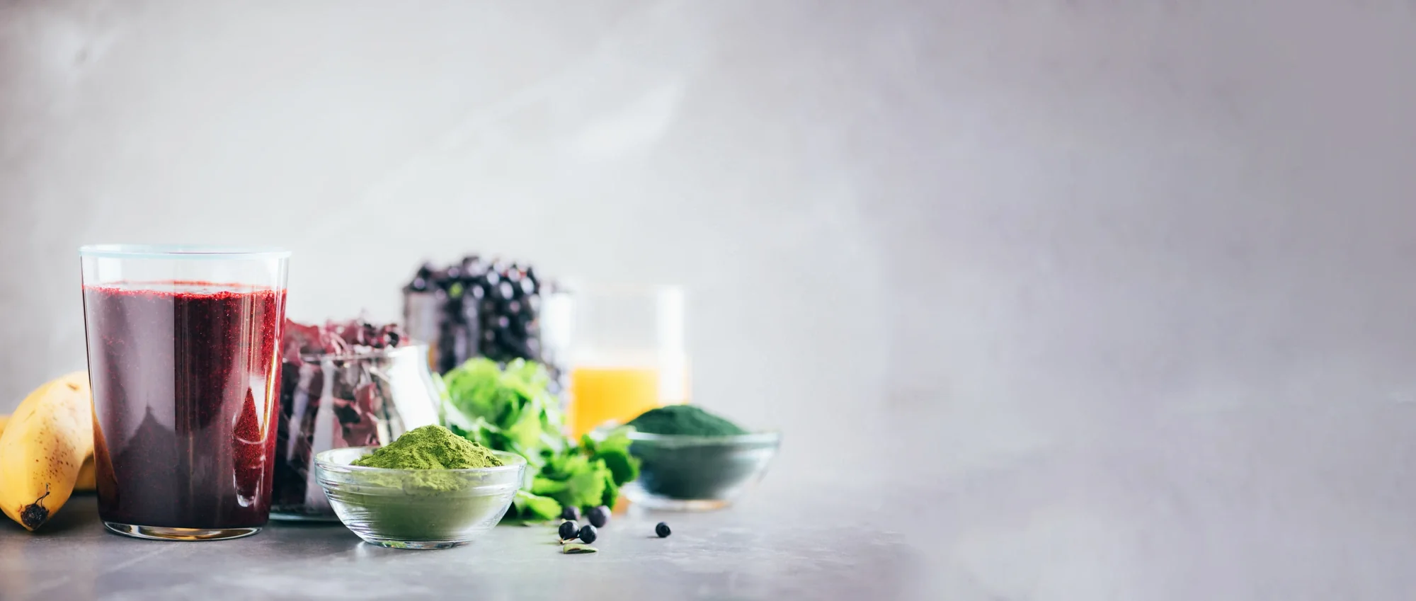 Superfood smoothie with green and berry powders and fresh produce