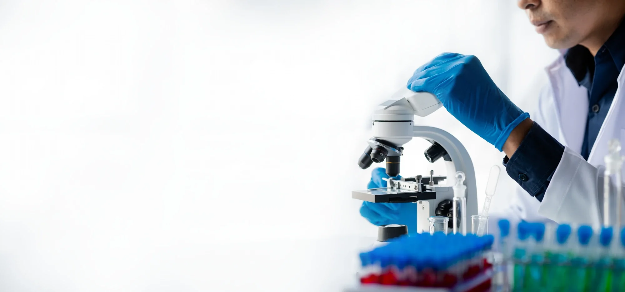 Analyst pipetting a sample at a laboratory microscope station