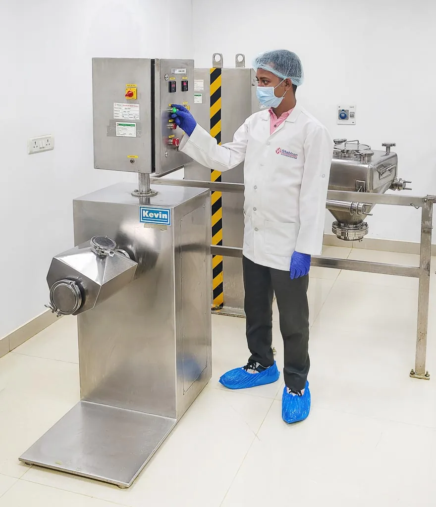 Operator at the oscillating granulator preparing granules in the Stabicon processing suite